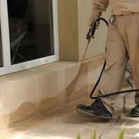 General pest control technician spraying exterior perimeter around a home in Salt Lake City, UT